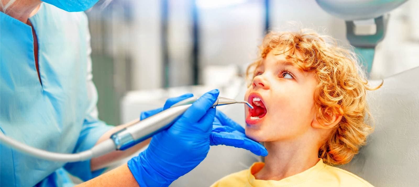 pretty little boy in dental office, having his teeth checked by