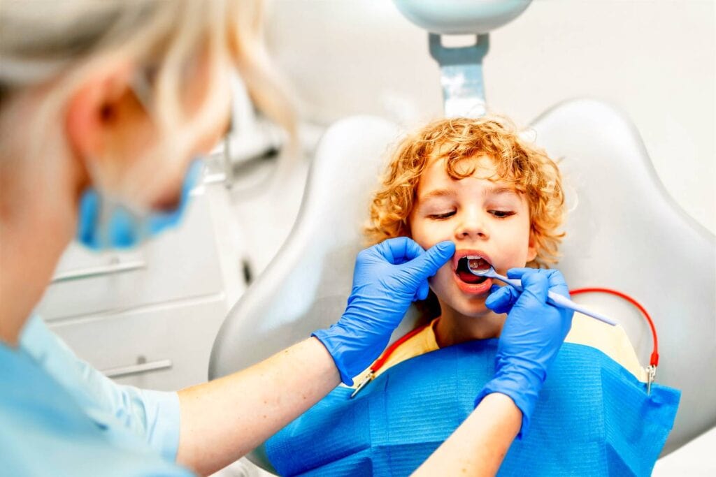 pretty little boy in dental office, having his teeth checked by