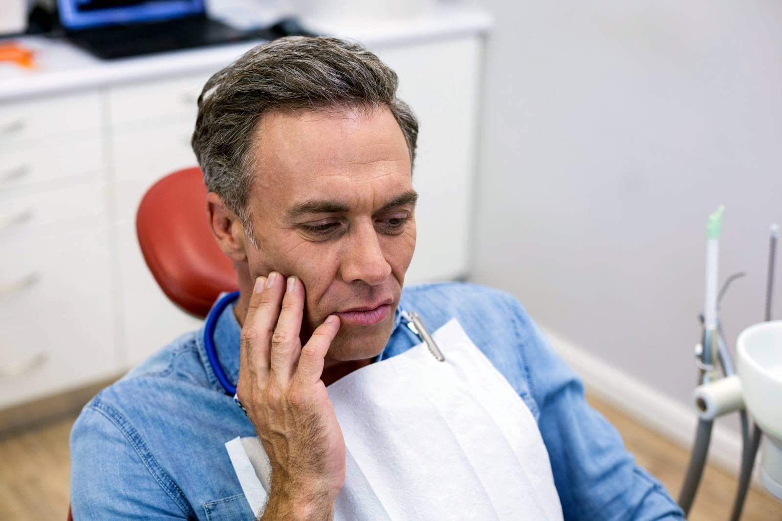 unhappy man having a toothache in dental clinic